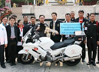 Mayor Itthiphol Kunplome (center right) hands over the symbolic keys to the new motorcycle to Pol. Col. Nanthawut Suwanla-Ong (center left).
