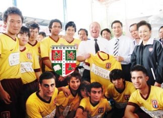 Prime Minister Abhisit Vejjajiva, standing 4th right, receives a Regents School soccer jersey from Phil Larkin, standing 6th right, the coach of the Regents team.