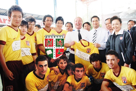 Prime Minister Abhisit Vejjajiva, standing 4th right, receives a Regents School soccer jersey from Phil Larkin, standing 6th right, the coach of the Regents team. 