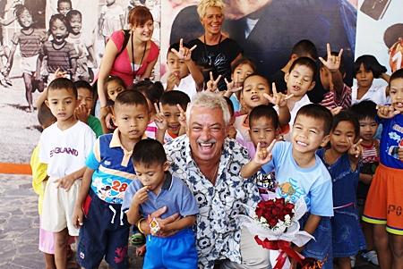 Danish singing legend Johny Reimer, center, a longtime supporter of the Pattaya Orphanage, enjoys a tremendous reception from the kids on his well received return visit.