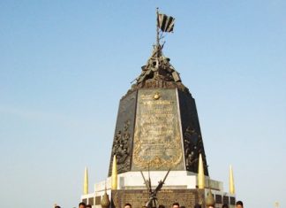 Rear Adm. Traikwan Krairuek and navy personnel pose with the children from the south in front of the Royal Thai Marines monument.