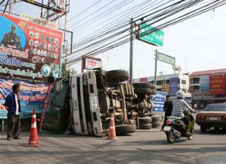 Driver Kan Kanhawong (left) stands next to the overturned cement truck he crashed in Sattahip.