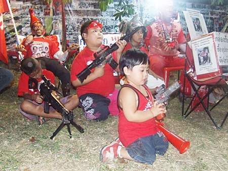 Teaching them young - children of the red shirt movement play with toy guns during the fund-raising rally in Pattaya. 