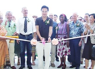 Prinn Panichpakdi from CLSA cuts the ribbon to officially open the new center, as supporters of the CPDC cheer him on.