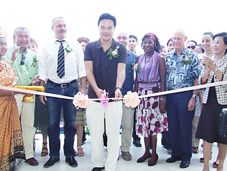 Prinn Panichpakdi from CLSA cuts the ribbon to officially open the new center, as supporters of the CPDC cheer him on. 