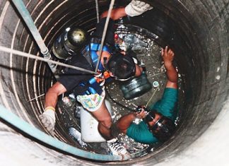 A rescue worker is lowered into the well to retrieve 15-year-old Kittipong.
