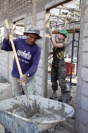 A Royal Thai Navy Marine, left, from the Royal Thai Engineer Battalion, and U.S. Marine Corps Lance Cpl. Nicolette Hawkins apply stucco to a new building at Baan Pong Wua School in Chantaburi, as part of Exercise Cobra Gold. (U.S. Marine Corps photo by Cpl. Patricia D. Lockhart/Released)