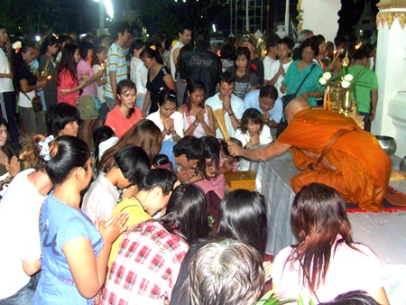Buddhist devotees receive a blessing from a monk at Wat Chaimongkol in South Pattaya.