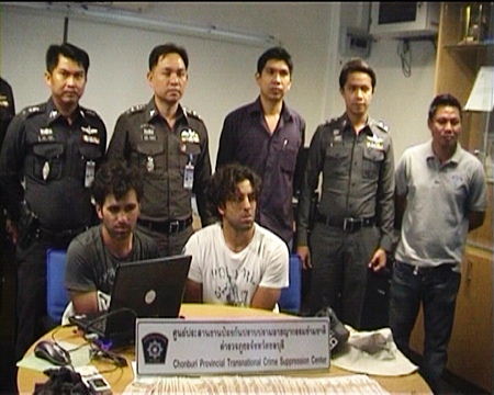 French nationals Alexandre Giro Zinno and Ali Ennouri (seated) are held for questioning at Pattaya Police Station following their arrest on Feb. 15.