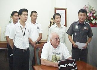 73-year old British national, Roderick William Robinson (seated), is detained by Chonburi Immigration officers.