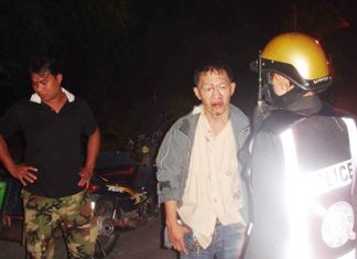 A badly beaten Sithichok Pipatsin explains to a police officer how he was attacked by two assailants.