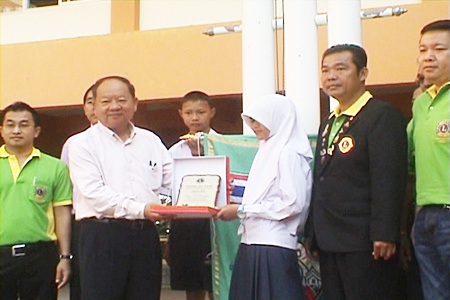 Nongprue Mayor Mai Chaiyanit presents a plaque to painting contest winner Sara Yimwilai.