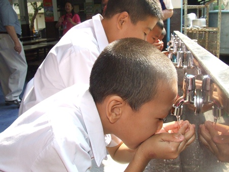 Children drink from the stainless steel trough where the water is obtained.