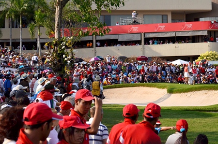 Huge crowds gather around the 18th green as the final pairing prepare to putt out.
