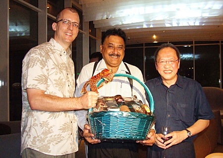 Harald Feurstein, GM of the Hilton Pattaya presents a gift to Peter as Chatchawal happily looks on.