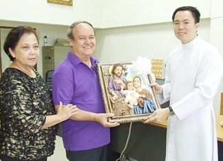 Father Francis Xavier Kritsada Sukkaphat presents an exquisite framed holy sculpture of the Nativity scene to Supanee and Premprecha Dibbayawan.