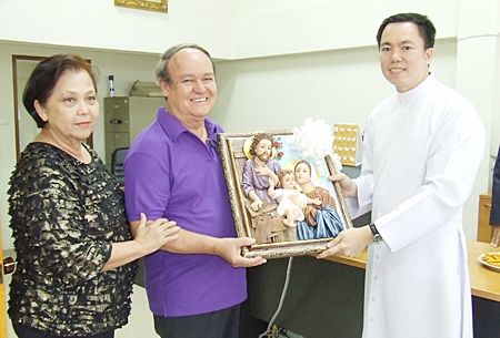 Father Francis Xavier Kritsada Sukkaphat presents an exquisite framed holy sculpture of the Nativity scene to Supanee and Premprecha Dibbayawan.