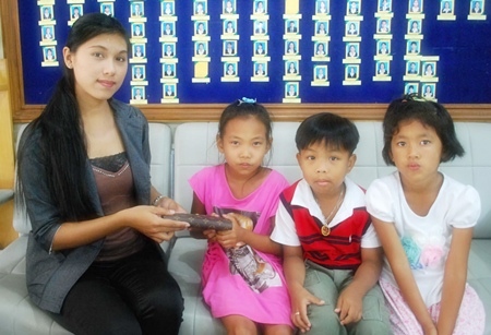 Supanida Chairat, 8, Korakot Arun, 6, and Chonthicha Khempet, 7, return the lost purse to Tasanee Pha-Indee. 
