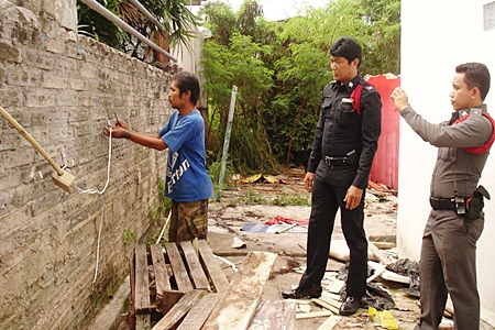 Wichian Dokmai shows police how he tried to steal electric wire from his neighbor. 