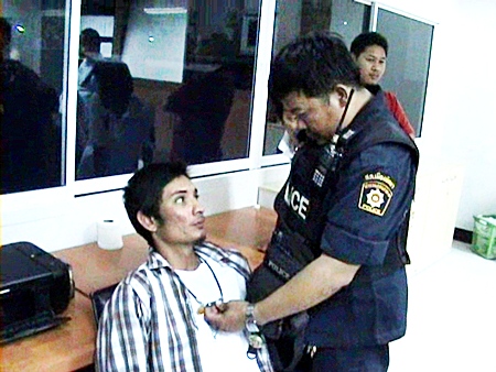 Finlip Kongnoi, seated, is held for questioning at Pattaya Police Station, Tuesday, March 1.