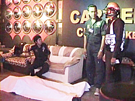 The body of Briton Anthony Rollins lies covered on the floor of the Cartier Karaoke as police wait to question staff members there.