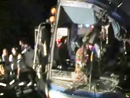 Rescue workers struggle to free injured passengers from the badly damaged tour bus.