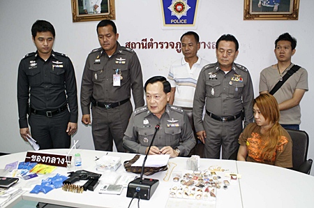 Thipawan Na Patalung, seated right, sits with police offers as confiscated drugs are displayed at Banglamung Police Station.