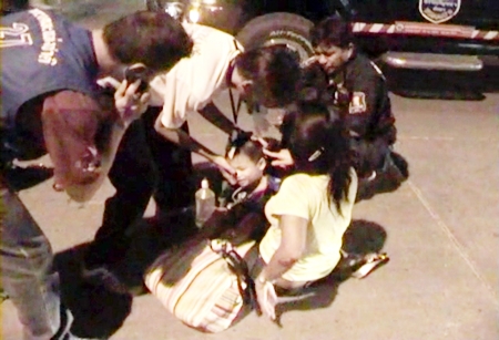 Jom Konprakun and her young son are helped by medical staff at the scene of the crash.