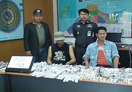 Prapat Sainai and Sakchai Pungen, seated, are held for questioning at Pattaya Police Station. 