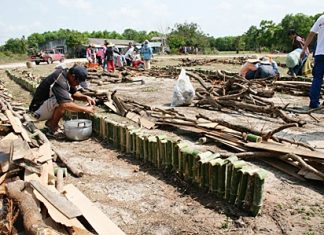 Men pour the sticky rice into the bamboo in preparation of roasting.