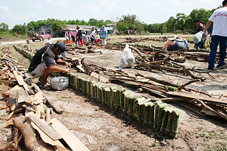 Men pour the sticky rice into the bamboo in preparation of roasting.