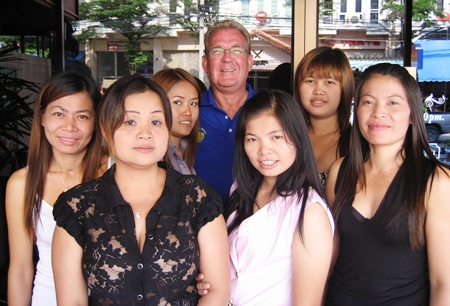 ‘Broken Wing’, center-rear, celebrates his golfing success with the staff at Kisses Bar in Ban Chang. 
