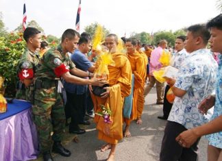Enlisted men and officers present offerings of rice, dried food and other items to monks from Rangsri Sunthorn Temple.