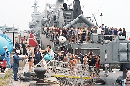 Tourists disembark from the HTMS Sukhothai in Sattahip after being rescued from flood-ravaged resorts in Koh Tao and Koh Phangan.  Royal Thai Navy ships rescued more than 800 tourists who had been stranded there during the recent foul weather. 