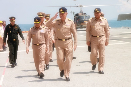 Supreme Commander Gen. Songkitti Jaggabatara returns salutes as he boards the HTMS Chakri Naruebet to watch naval exercises off Sattahip.