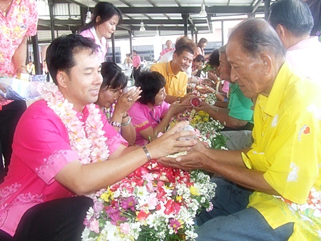 Mayor Itthiphol Kunplome pours water on the hands of senior citizens and receives blessings in return. 