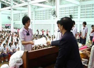 Principal Warakorn Ruenkamol hands out diplomas to 577 students at Banglamung School, Thursday, March 31.