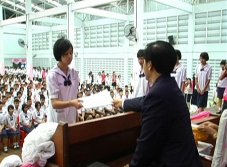 Principal Warakorn Ruenkamol hands out diplomas to 577 students at Banglamung School, Thursday, March 31.