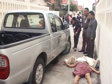The body of 44-year-old Somwang Ngamying lies next to a pickup truck close to her home after she was found with fatal knife wounds.
