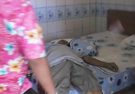 The deceased lying on his bed