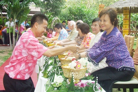 Khomsan Seesam (left) leads staff of the Diana Group to perform the rod nam dam hua ceremony to show their respects to Sophin Thappajug and other elders of the community. 