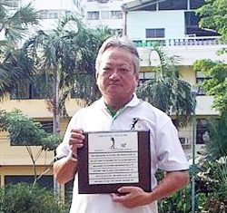 William Chang holds up his ‘hole in one’ plaque.