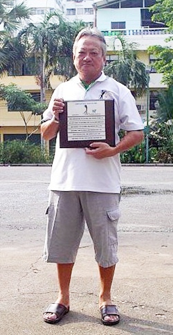 William Chang holds up his ‘hole in one’ plaque. 