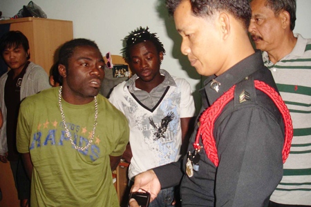 The two Cameroonian football players are arrested by police at their south Pattaya apartment.