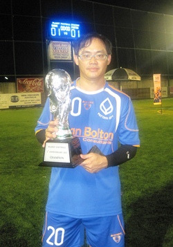 Pongsak, captain of the Bangkok Bank team, holds up the winners’ trophy.