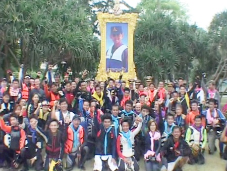 The Jet Ski Riders pose for a photograph under a picture of His Majesty the King
