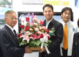Pakorn Thavisin, left, Chairman LPN Development Public Company Ltd., receives a bouquet of flowerers from Pattaya Mayor Ithiphol Khunpluem congratulating him on the launch of the project.