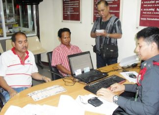 Somsak Satiplan and Veera Poonsuk turn the money over to police.