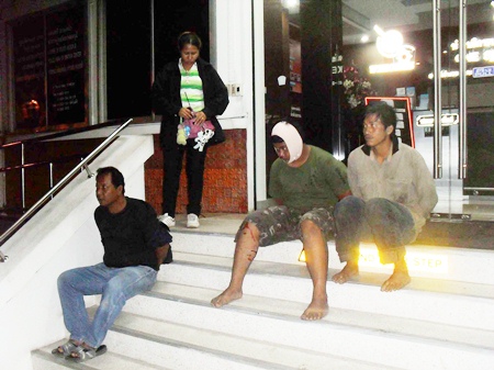 Officers detain the three suspects on the front steps of the police station. 