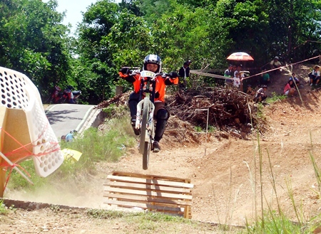 A rider flies over a ramp on the downhill course.